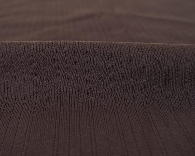 May include: Close-up of a brown ribbed fabric with a subtle texture.