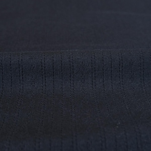 May include: Close-up of a dark blue fabric with a textured, ribbed pattern. The fabric has a smooth, soft feel.