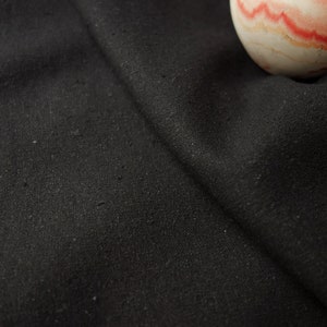 May include: A close-up of a black fabric with a textured surface.
