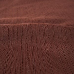 May include: Close-up of a brown ribbed fabric with a subtle texture.