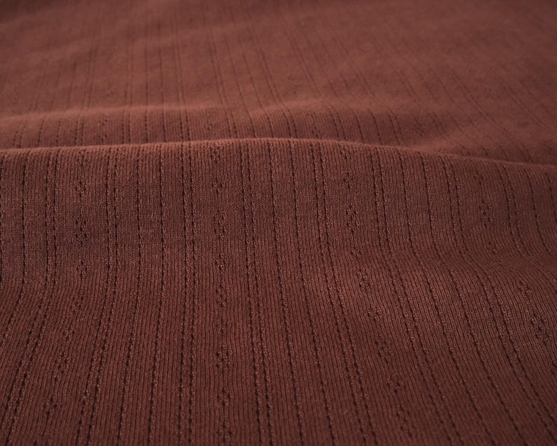 May include: Close-up of a brown ribbed fabric with a subtle texture.
