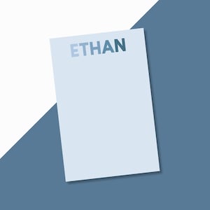 May include: A light blue card with the name "ETHAN" printed in a gradient of blue.
