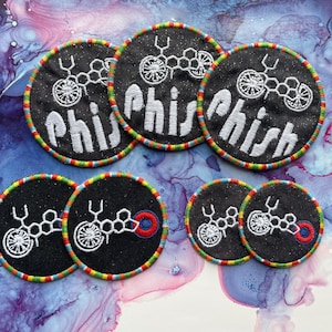 May include: Six round embroidered patches with a colorful border. The patches feature a black background with a white graphic of a molecule and the word "Phish" in white text.