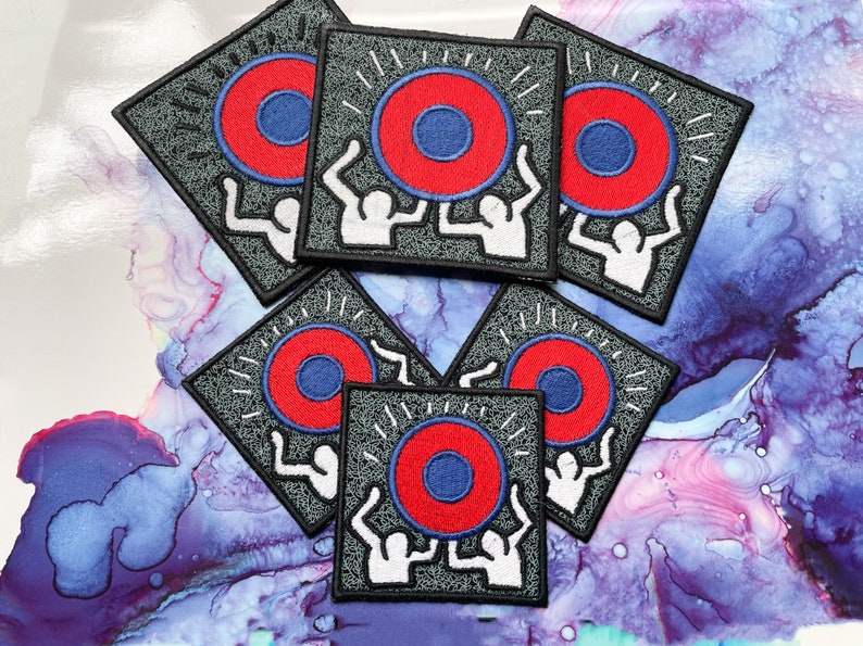 May include: Six gray square patches with white outlines. Each patch features two white figures lifting a red and blue circle with white rays emanating from the circle.