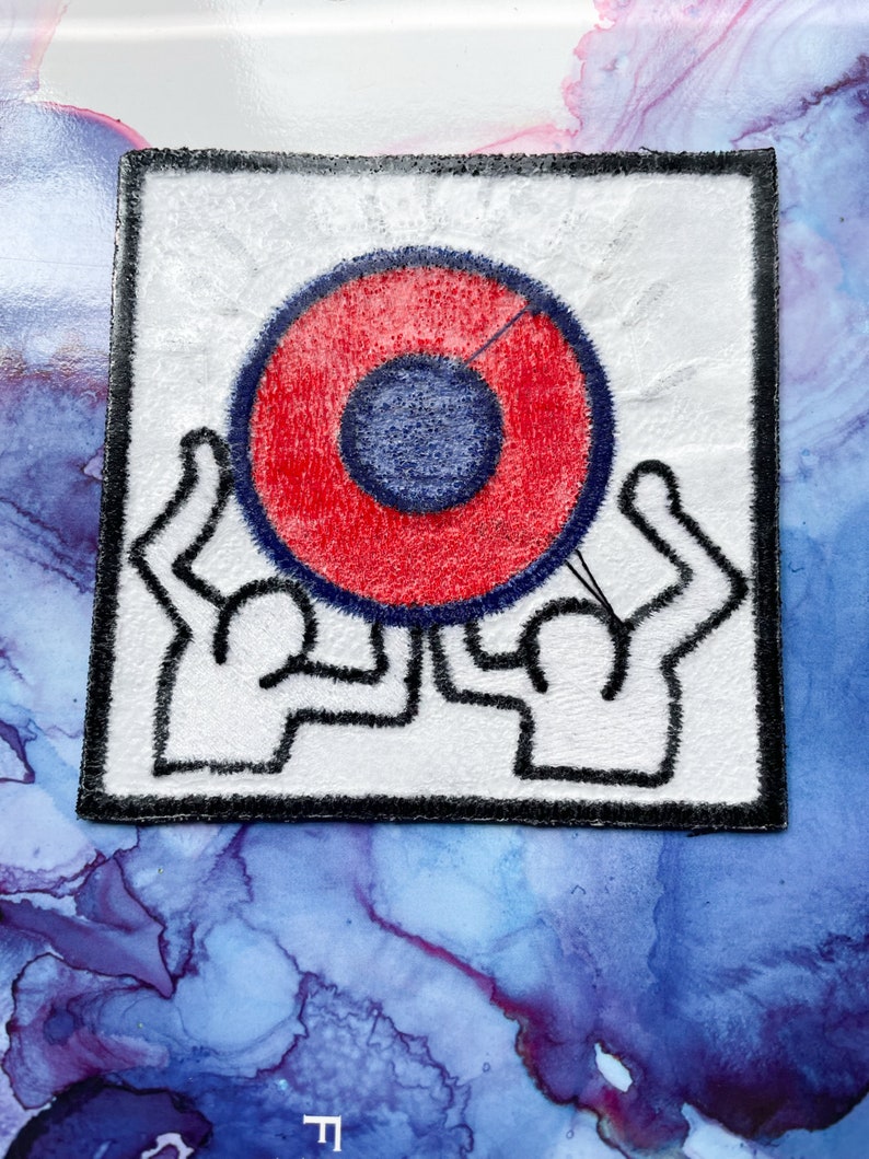 May include: A white patch with a black border features a red and blue circle with two stylized figures holding it up.