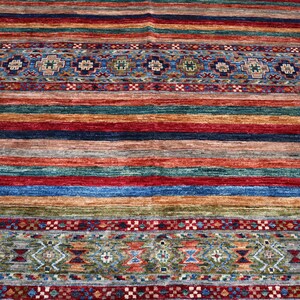 May include: A colorful rug with a striped pattern and intricate border designs. The rug features a variety of colors, including red, blue, green, and brown.