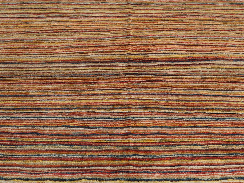 May include: Multicolored striped rug with a variety of shades of red, orange, yellow, brown, and blue.