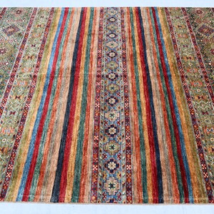 May include: A colorful rug with a striped pattern and intricate designs. The rug features a variety of colors, including red, blue, green, and yellow.
