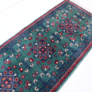 Pu&ograve; includere: Un tappeto verde con un designo persiano tradizionale con accenti rossi e blu. Il tappeto ha un bordo con frange.