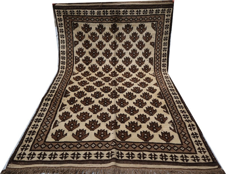 May include: A traditional rug with a cream background and a repeating pattern of brown stylized flowers. The rug has a brown border with a geometric design.