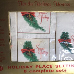 May include: Holiday place setting set with embossed placemats, dinner napkins, cocktail napkins, and coffee coasters. The napkins and coasters feature a green pine branch with a red bow and the words "Season's Greetings". The set includes 32 pieces.