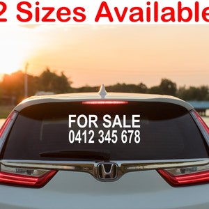 May include: White car with a black rear window displaying a white sticker that reads "FOR SALE 0412 345 678".