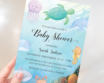 Può includere: Un invito rettangolare per baby shower con illustrazioni ad acquerello di una medusa viola, tartaruga marina verde, delfino blu, cavalluccio marino arancione, balena e granchio. Il testo recita: Please join us for a Baby Shower honoring Sarah Jackson, Saturday, December 19, 12-3 PM, 7025 Roosevelt Ave Los Angeles, CA 90044, RSVP by to Megan at 123-456-7890, Registry at Amazon & Target.