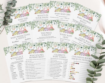 Puede incluir: Un conjunto de tarjetas de juegos para baby shower con temática de dinosaurios. Las tarjetas presentan varios juegos como "Baby Mad Libs", "Baby Shower Bingo" y "¿Adivina quién? Mamá o Papá?". Las tarjetas tienen un esquema de color verde y pastel.