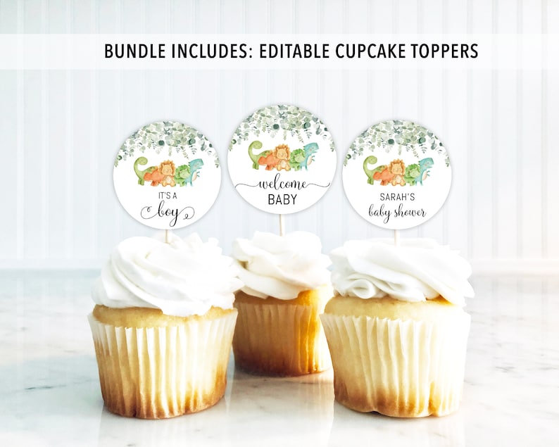 May include: Three round cupcake toppers with green foliage and dinosaurs. The toppers say "It's a boy", "Welcome Baby", and "Sarah's Baby Shower".