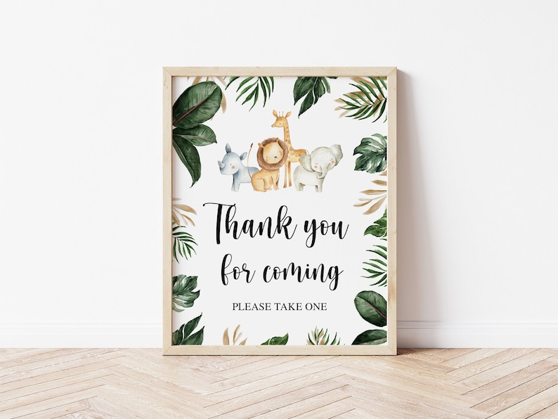 May include: A rectangular sign in a light wood frame featuring watercolor illustrations of a rhino, lion, giraffe, and elephant surrounded by green tropical leaves. The text reads Thank you for coming and PLEASE TAKE ONE in black font.