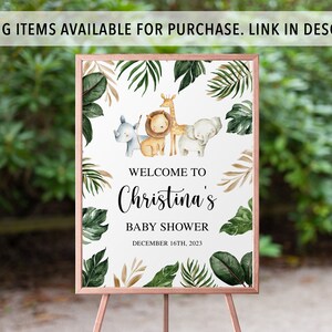 May include: A rectangular sign in a copper-colored frame featuring watercolor illustrations of a rhino, lion, giraffe, and elephant surrounded by green tropical leaves. The text reads: WELCOME TO Christina's BABY SHOWER DECEMBER 16TH, 2023.