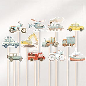 May include: A set of 12 watercolor-style vehicle cupcake toppers. The toppers feature a variety of vehicles, including a police car, a motorcycle, a helicopter, a train, a tractor, a dump truck, a fire truck, a bicycle, a boat, and an excavator. The toppers are printed on cardstock and attached to wooden sticks.