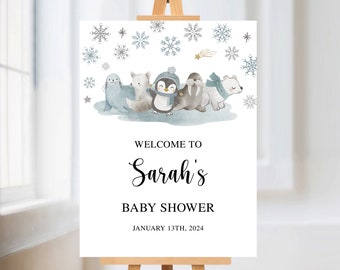 May include: Welcome to Sarah's Baby Shower sign with a watercolor illustration of a penguin, polar bear, walrus, and arctic fox on a blue background with snowflakes. The date of the shower is January 13th, 2024.