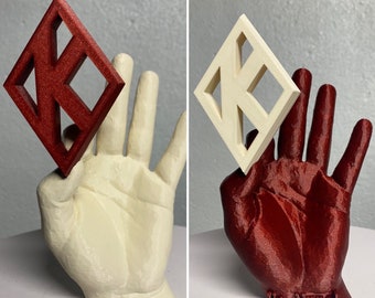 May include: A 3D-printed sculpture of a hand holding a diamond-shaped object. The hand is cream-colored, and the diamond is red. The diamond has a geometric design. The text "Yo, Nope!" is at the base of the red hand.