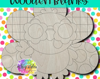 May include: A wooden owl-shaped blank with a grid pattern on the head and flower-shaped glasses. The text "Wooden Blanks" is at the top. The background is a colorful polka dot pattern.