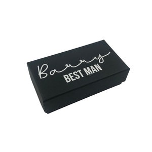 May include: Black gift box with the text "Best Man" in white lettering.