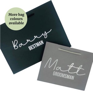 May include: Two gift bags with white lettering. One bag is dark green with the text "Barry BESTMAN". The other bag is grey with the text "Matt GROOMSMAN".