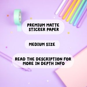 May include: A close-up of a pastel purple surface with a roll of light blue washi tape, a pink notepad, and three white rounded rectangles with black text. The text on the rectangles reads "PREMIUM MATTE STICKER PAPER", "MEDIUM SIZE", and "READ THE DESCRIPTION FOR MORE IN DEPTH INFO".