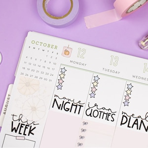 May include: A monthly planner with a green background and a calendar for October. The planner has a section for each day of the week, with space for writing tasks and appointments. The planner also includes a section for notes and a section for goals. The planner is decorated with stickers and washi tape.