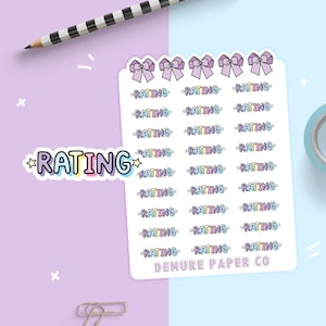 May include: A sheet of colorful stickers with the word "RATING" repeated multiple times. The stickers are decorated with bows and stars. The sheet also includes the text "DEMURE PAPER CO."