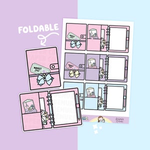 May include: A sheet of planner stickers featuring a pink, purple, and blue color scheme. The stickers include a foldable planner design with an "ADMIT ONE" ticket, a bow, and a claw machine graphic. The text "FOLDABLE" is also present.