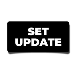 May include: Black rectangular sign with white text that reads "SET UPDATE".