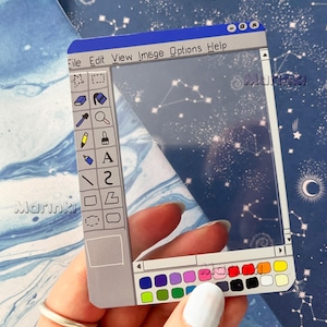 Peut inclure: Un autocollant rectangulaire transparent présentant le design d'une interface de logiciel graphique rétro. Le cadre comprend une barre de menu avec File, Edit, View, Image, Options, Help, une barre d'outils verticale et une palette de couleurs.