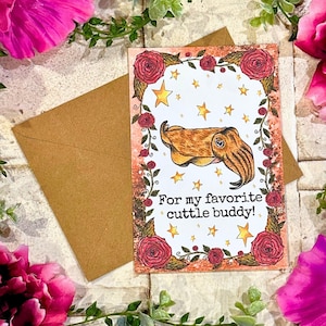 May include: A greeting card with a watercolor background featuring a cartoon cuttlefish with a floral border and the text "For my favorite cuttle buddy!"