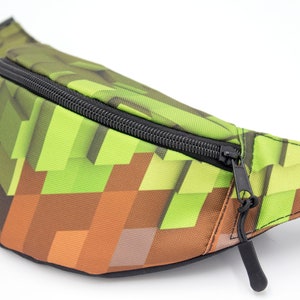 May include: A green and brown pixelated fanny pack with a black zipper and strap.