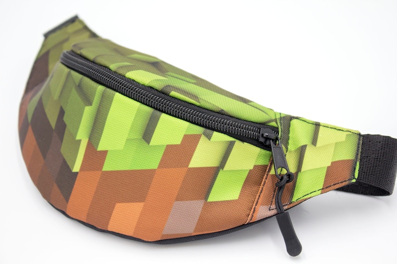 May include: A green and brown pixelated fanny pack with a black zipper and strap.