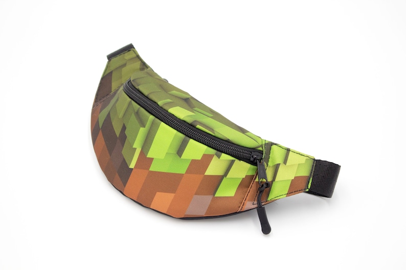 May include: A green and brown pixelated fanny pack with a black zipper and strap.