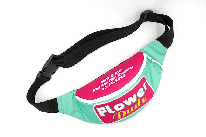May include: A teal and pink fanny pack with a black adjustable strap and buckle. The fanny pack has the words "Flower Dude" in a retro font and the names "Kate & Jack" and the date "15.10.2021" printed on it.