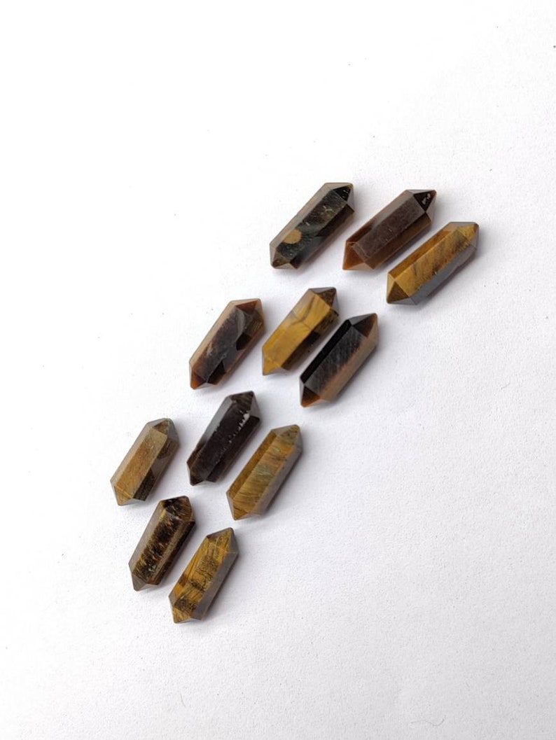 Natural Tiger Eye faceted pencil stones arranged together for jewelry making and gemstone crafts