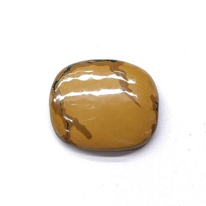 May include: A smooth, polished, light brown gemstone with dark brown veins and a slightly oval shape.