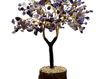 Könnte beinhalten: Ein lila Amethyst-Kristallbaum mit einer goldenen Drahtbasis und einer braunen Holzbasis. Der Baum steht vor einem weißen Hintergrund.