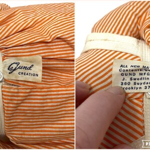 Op de afbeelding: Oranje en wit gestreepte stoffen pop met een Gund Creation-label en een label met de tekst "ALL NEW MATERIAL Contents: Cotton, Polyester, QUND MFG. CO. J. Swedlin Inc. 360 Suydam St. Brooklyn 37. N."