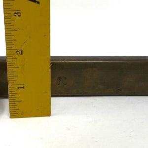 May include: A brass box with a smaller brass box attached to it. The boxes are both rectangular and have a slightly rounded edge. The larger box is about 7 inches long.