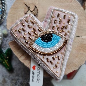 Evil Eye Heart Brooch – Hand Embroidered Pink Heart with Blue Eye – Protection Jewelry – Symbolic Gift for Her – Beaded Statement Pin