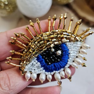 Beaded Evil Eye Brooch – Handmade Embroidered Protection Pin – Gold and Blue Crystal Eye Jewelry – Unique Statement Accessory