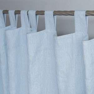 May include: Light blue linen curtains with a simple, modern design. The curtains are hung on a metal rod and have a gathered look.