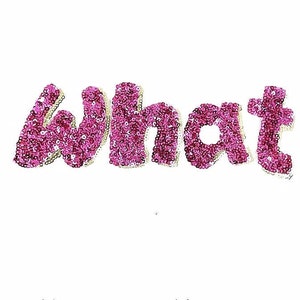 Peut inclure: Le mot "what" écrit en paillettes roses.