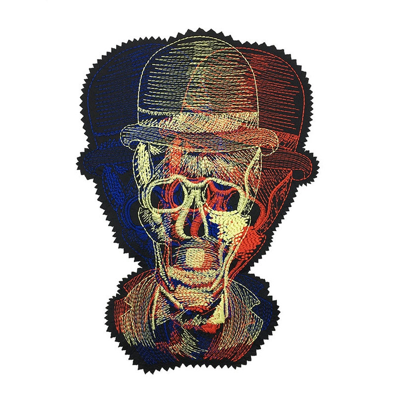 May include: An embroidered patch featuring a skull wearing a bowler hat and a suit jacket. The design uses a layered, tri-color effect with overlapping red, blue, and yellow stitching, creating a visual offset that mimics a 3D anaglyph graphic style.