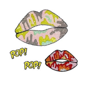 May include: Two iron-on patches featuring lips with a camouflage pattern. The larger patch is in shades of pink, green, and yellow. The smaller patch is in shades of red, orange, and pink. Both patches have the word "POP!" written in yellow.