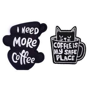 Puede incluir: Dos parches bordados negros para planchar. Un parche presenta una taza de café con el texto "Necesito más café". El otro parche presenta un gato negro dentro de una taza de café con el texto "El café es mi lugar seguro".